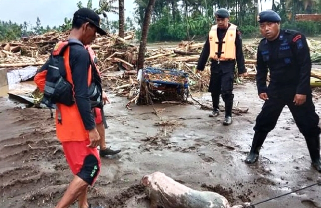Anggota Tim SAR Batalyon C Pelopor Satbrimob Polda Bali membersihkan jalan Denpasar - Gilimanuk dari sampah kayu saat banjir bandang menerjang Jembrana. Foto: Instagram @satbrimobdabali.
