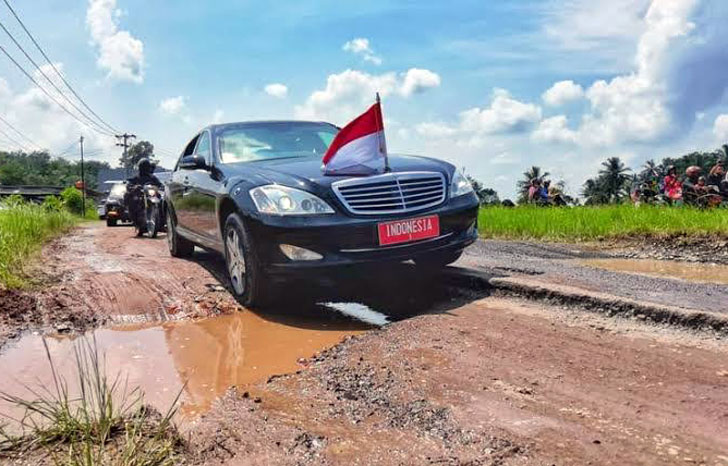 Presiden Joko Widodo (Jokowi) melintasi jalan rusak dalam kunjungannya ke Provinsi Lampung, Jumat (5/5/2023). Dalam kunjungan ini Jokowi menyatakan jika pemerintah daerah tak mampu memperbaiki jalan yang rusak maka akan ditarik ke pusat.(Istimewa/Agus Suparto).