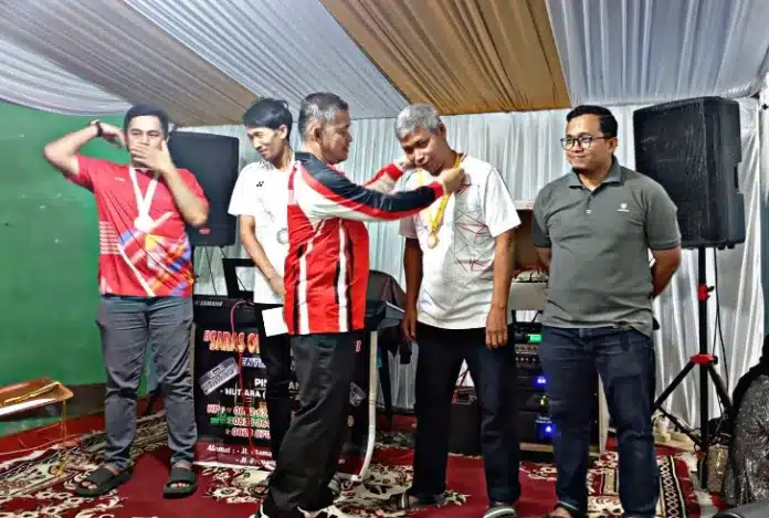 Ketua Komite Olahraga Nasional Indonesia (KONI) Kota Padang, Erianto, didampingi Sekretaris KONI Kota Padang, secara resmi menyerahkan medali kepada para pemenang Turnamen Badminton Mahmuda Cup VII 2026. Kegiatan tersebut berlangsung di Hall Pak Datuk, Kelurahan Belimbing, Kecamatan Kuranji, Kota Padang, pada Sabtu (24/1/2025) malam.
